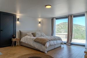 a bedroom with a bed and a large window at Villa ROYA in Saint-Florent