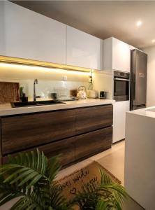 a kitchen with white cabinets and stainless steel appliances at Sea La Vie in Keramídhion