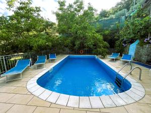 a swimming pool with blue chairs around it at Limoneto by Espresso Rentals in Massa Lubrense