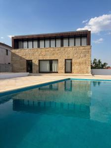 a building with a swimming pool in front of a building at Seven Books House in Carrazeda de Anciães