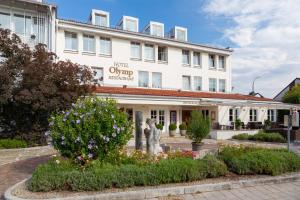 ein Hotel mit Blumen vor einem Gebäude in der Unterkunft Olymp Munich in Eching