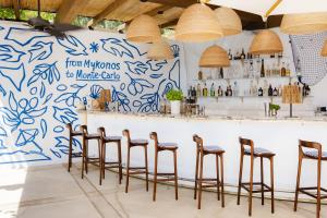 a bar with stools in a restaurant with a blue and white wall at Monte-Carlo Beach in Roquebrune-Cap-Martin