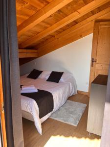 a bedroom with a bed in a room with wooden ceilings at Chalet Mary in La Côte dʼArbroz