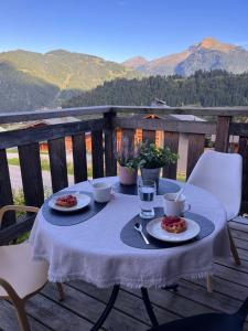 a table with plates of food on top of a deck at Chalet Mary in La Côte dʼArbroz