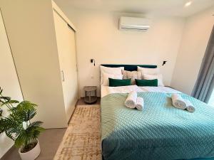 a bedroom with a bed with two towels on it at Local-Lux Garden Residence A- 2 Bedrooms-Terrace in Kecskemét