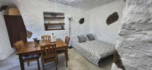 a dining room with a table and a couch in a cave at Cuevita El Abrigo - 1 dormitorio in Lomo de Arico