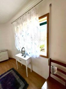 a room with a window and a table with a mirror at Quarto em Bragança in Bragança