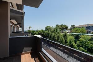 a balcony of a building with a view of trees at OLYMPIADA GIRNI Suites in Paralia Katerinis