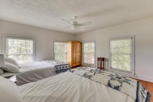 two beds in a room with two windows at Waterfront Home with Large Yard, Dock & Bay View in Heathsville