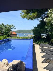 a swimming pool with a view of the water at Family Apartments Monika - sea view - heated pool in Punat