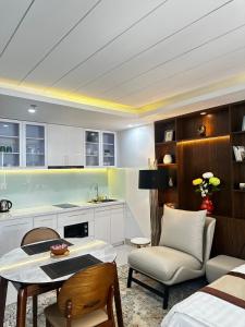 a kitchen and living room with a table and a chair at Berlin Haus Nha Trang Hotel in Nha Trang