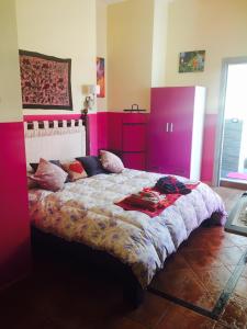 um quarto com uma cama grande e paredes cor-de-rosa em Mondello Room em Mondello
