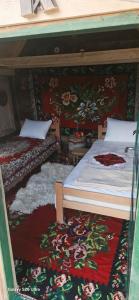 a bedroom with two beds and a rug at Ivovik in Rožaje