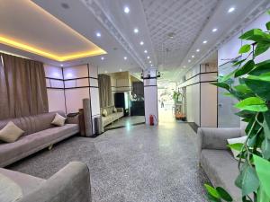 a living room with couches and a potted plant at Abed Masoudi Ajyad Hotel-فندق عابد المسعودي in Mecca