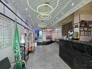 a restaurant with a bar with a menu on the wall at Abed Masoudi Ajyad Hotel-فندق عابد المسعودي in Mecca