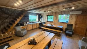 a large room with a wooden table and a staircase at Möllatsi Saunamaja in Möllatsi +16 photos