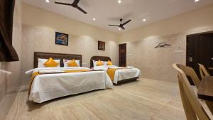 a hotel room with two beds and a table at Kanchi Crown Residency in Kanchipuram