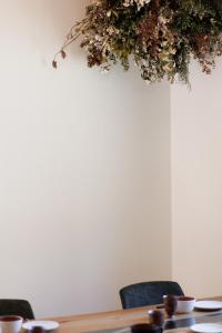 a table with chairs and a plant hanging from a ceiling at New Field Chalet 白馬 in Hakuba