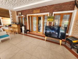 a living room with a large flat screen tv at Résidence Tina 1 in Ngalou Sessène