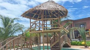 a wooden tower with a umbrella over a pool at Résidence Tina 1 in Ngalou Sessène