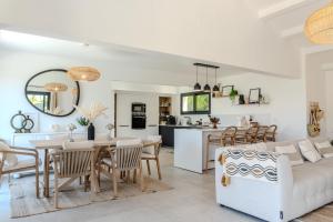 a living room and kitchen with a table and a couch at Villa ROYA in Saint-Florent
