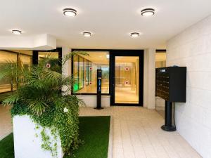 an entrance to a building with a plant at Apartments4you Queen in Bat Yam