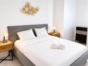 a bedroom with a large bed with two towels on it at Apartments4you Queen in Bat Yam +11 photos