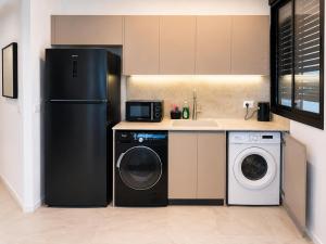 a kitchen with a refrigerator and a washing machine at Apartments4you Queen in Bat Yam