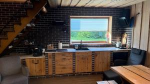 a kitchen with a sink and a window at Möllatsi Saunamaja in Möllatsi