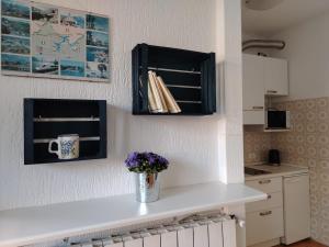 a kitchen counter with a vase of flowers on it at Casa Augusta in Maccagno Superiore