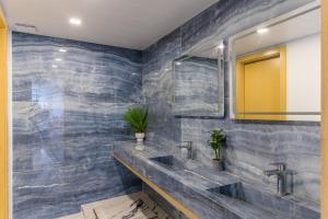 a bathroom with two sinks and a mirror at Cavella Apart Hotel in Monsef in Al Ḩulwah +50 photos