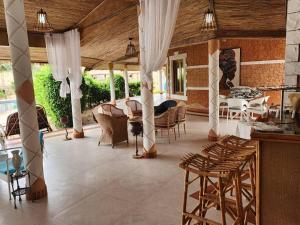 a living room with chairs and a table and a dining room at Résidence Tina 1 in Ngalou Sessène