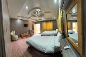 a hotel room with two beds and a living room at Summit Hotel Skardu in Skardu