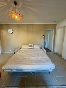 a large bed in a room with a clock on the wall at Le Cocon de Clisson in Clisson