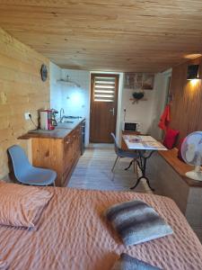 a bedroom with a bed and a kitchen with a desk at Gîte 3 "le Canal de Baza" aux Magnolias in Aubenas
