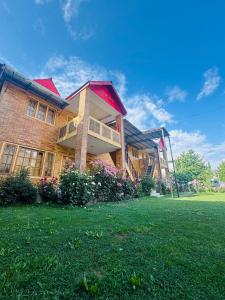 a large brick building with a lawn in front of it at Summit Hotel Skardu in Skardu