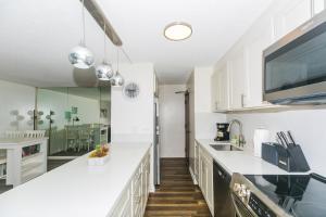 a kitchen with white cabinets and a large counter top at Discovery Bay 3513 in Honolulu