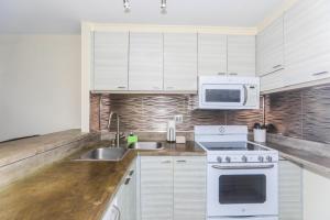 a white kitchen with a sink and a microwave at Ilikai Marina 1386 in Honolulu