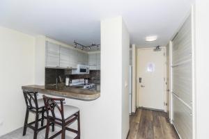 a kitchen with two chairs and a counter in a room at Ilikai Marina 1386 in Honolulu
