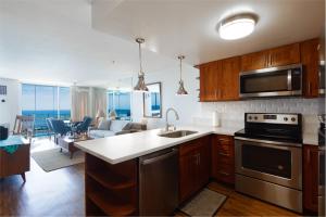 a kitchen and living room with a view of the ocean at Ilikai Marina 1394 in Honolulu