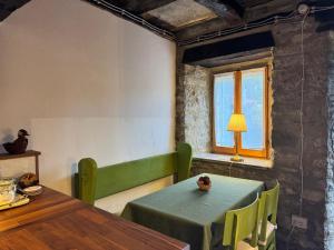 a dining room with a green table and a window at Il Rifugio - Cottage With Pool in Toano +20 photos
