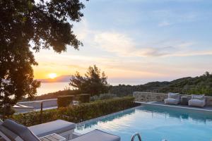a swimming pool with a view of the sunset at Atrium Villas in Kechria +28 photos