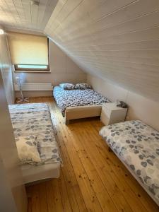 two beds in a room with wooden floors at Möllatsi Saunamaja in Möllatsi