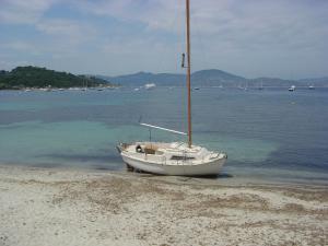 a sailboat sitting on the shore of a beach at Villa La Begude - Boutique B&B in Saint-Tropez
