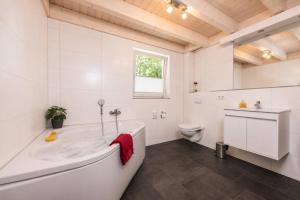 a white bathroom with a tub and a toilet at Lee - Nordhorn in Nordhorn