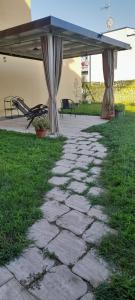 a stone walkway under an umbrella in a yard at Casa Carmela in Angera +5 photos