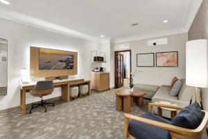 a living room with a couch and a desk at Best Western Plus Sunset Plaza Hotel in Los Angeles