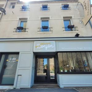 a store front of a building with a sign on it at Le Logis du Donjon 2 in Les Herbiers +2 photos