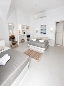 a white bedroom with two beds and a bathroom at Fira Centrum White in Fira