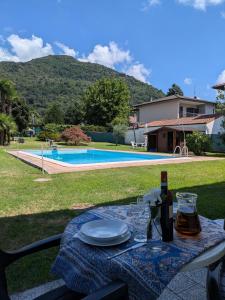 a table with plates and a bottle of wine on it at Casa Augusta in Maccagno Superiore